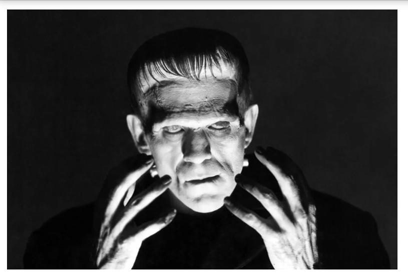 Frankenstein's monster raising its hands, in a black-and-white still